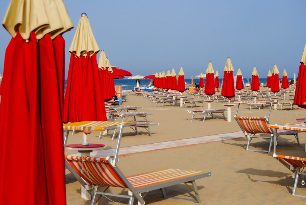 Spiaggia di Rimini, ombrelloni rossi, lettini
